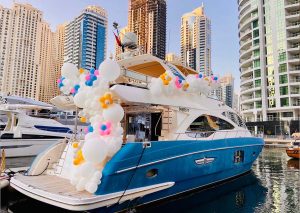 A vibrant yacht party in Dubai at sunset, with guests enjoying the stunning view of the city's skyline from the deck of a luxurious yacht